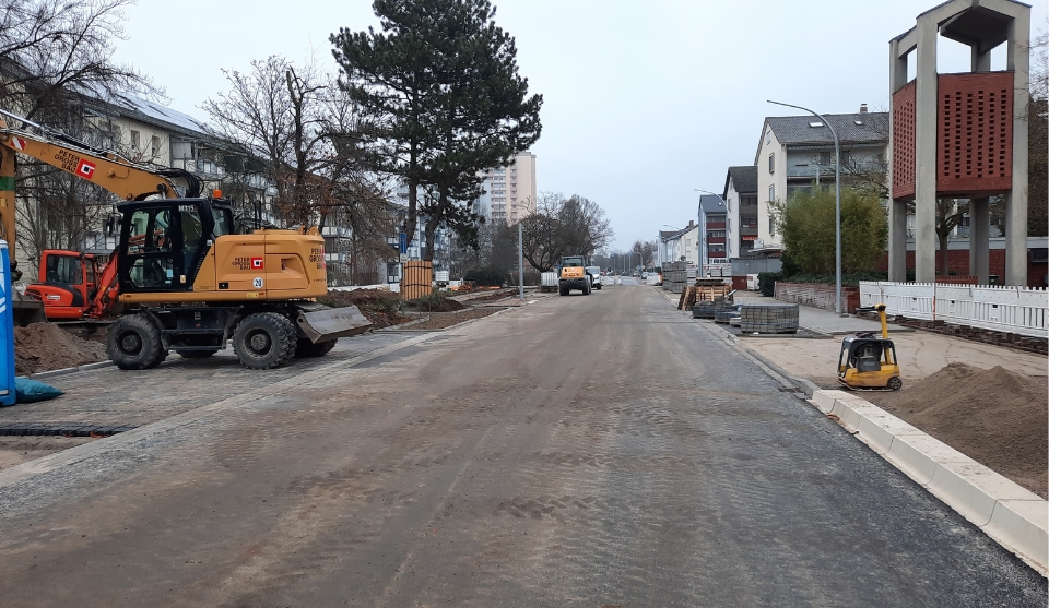 Blick auf die Baustelle: Lange Straße mit Bagger und Baustellenfeeling