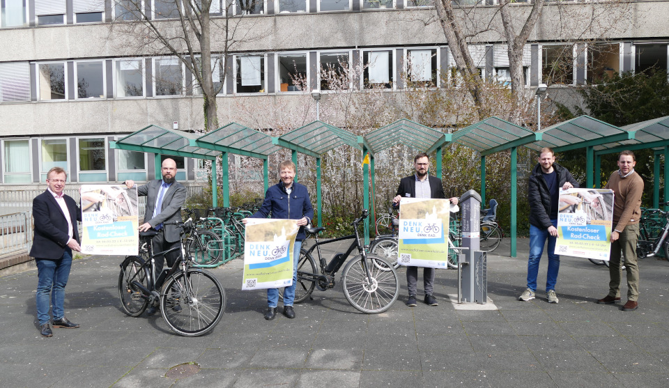 Sechs Männer stehen vor Fahrradständern und halten Plakate in den Händen