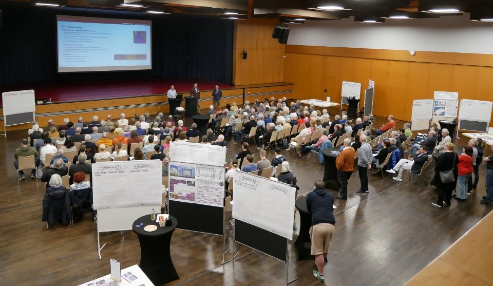 Menschen im großen Saal des Bürgerhauses: Im Vordergrund die Projekttische