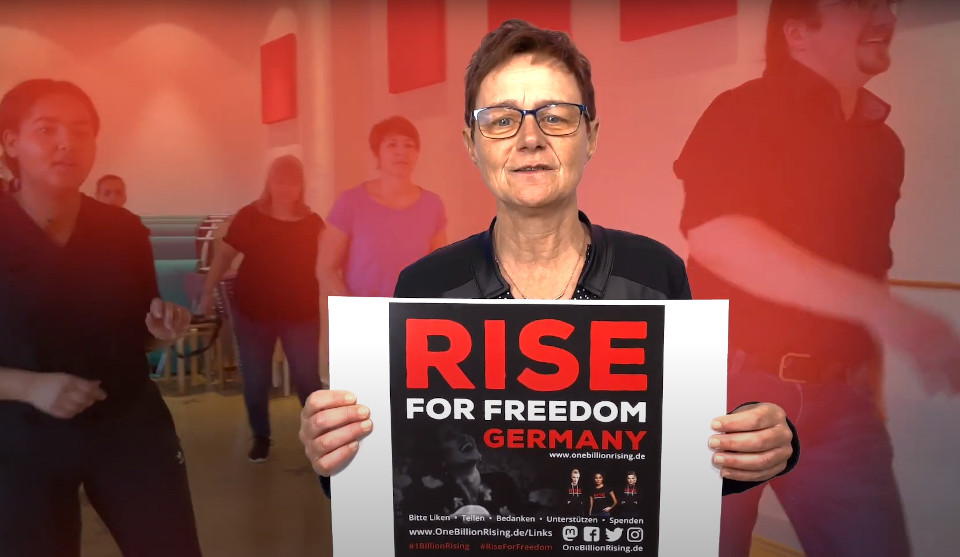 Frau hält Plakat Rise for Freedom hoch