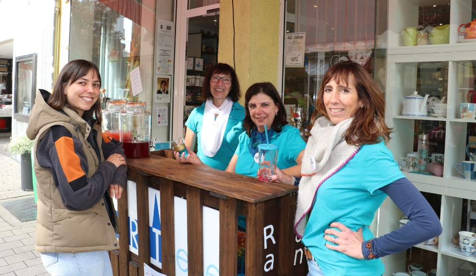 Die Teefachfrauen von ARTee Tina Kempf, Edith Kempf und Alexandra Thomas stehen mit einer Kunden im freien an einem Tresen. Im Hintergrund das Geschäft. 