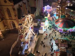 Kerweplatz von oben bei Nacht mir Fahrgeschäften, Lichtern und Menschen