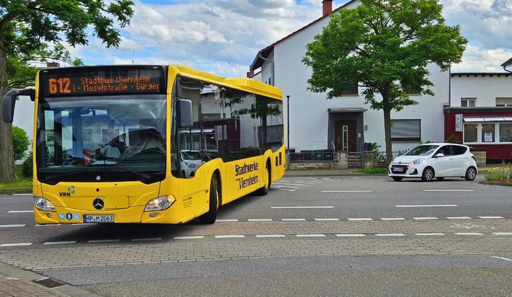 Stadtbus während der Fahrt frontal aufgenommen. Gelber Bus
