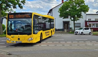 Stadtbus während der Fahrt frontal aufgenommen. Gelber Bus