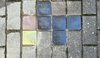 Mehrere Stolpersteine sind zwischen grauen Pflastersteinen in den Boden eingelassen. Die Gedenksteine erinnern mit Namen und Angaben zu Flucht, Deportation und Ermordung an Mitglieder der Familie Schindler. Der linke Stein glänzt und scheint neu zu sein. Er erinnert an Frieda Horn, geborene Schindler.