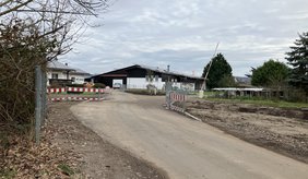 Straße mit geöffneter Schranke und Bauabsperrung