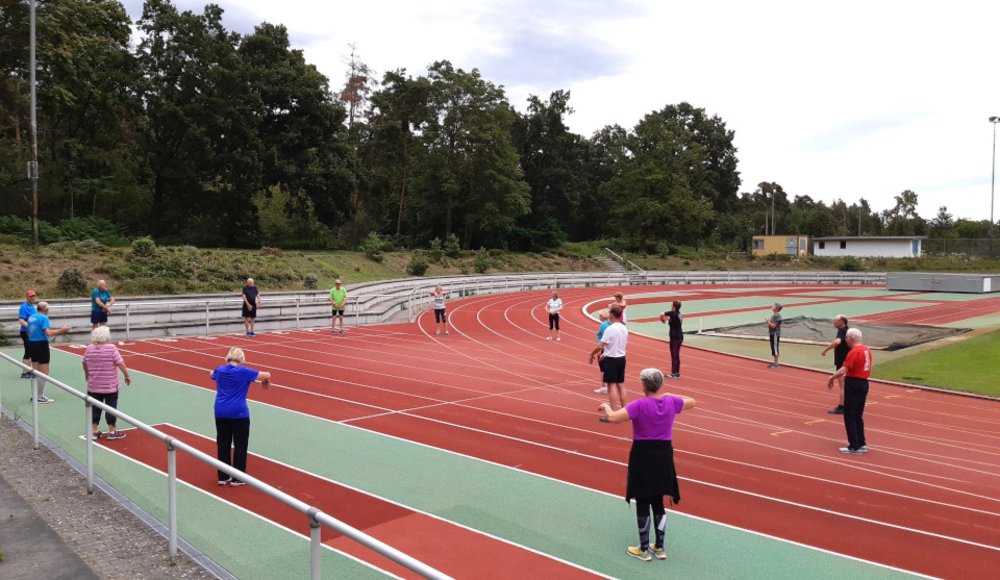Menschen die auf der Lauffläche im Stadion trainieren.