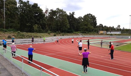 Menschen die auf der Lauffläche im Stadion trainieren.