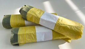Zu sehen sind drei Rollen gelbe Säcke.