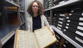 Elke Leinenweber im Magazin des MARCHIVUMS, zwischen den mit historischen Viernheimer Zeitungen gefüllten Regalen.