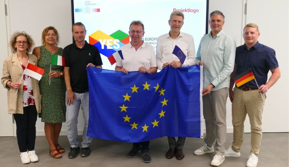 (v. l.): Susanna Garbo, Projektleiterin im Kultur- und Sportamt, Sabine Ruth und Lars Prechtl von der städtischen Jugendförderung, Bürgermeister Matthias Baaß, Schulleiter Thomas Blumenrath sowie Jan Krasko und Sascha Niebler vom Kultur- und Sportamt mit einer Europafahne in der Hand