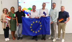 (v. l.): Susanna Garbo, Projektleiterin im Kultur- und Sportamt, Sabine Ruth und Lars Prechtl von der städtischen Jugendförderung, Bürgermeister Matthias Baaß, Schulleiter Thomas Blumenrath sowie Jan Krasko und Sascha Niebler vom Kultur- und Sportamt mit einer Europafahne in der Hand