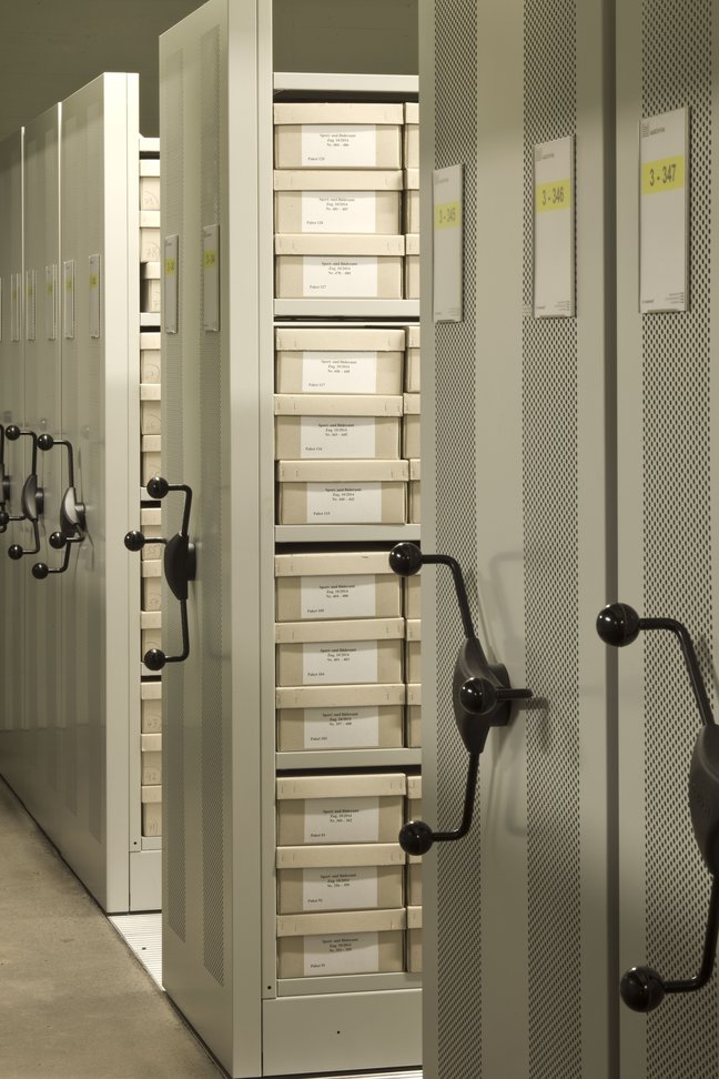 Ein Magazingeschoss mit Archivgut im Marchivum ©Kathrin Schwab Regal ist ausgefahren mit silbernen Kisten