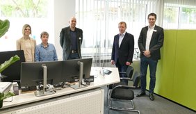 Offene und moderne Arbeitsplätze zur Erledigung der Anliegen für das Bürgerbüro-Team: (v. r.), Hauptamtsleiter Philipp Haas, Bürgermeister Matthias Baaß, Bürgerbüroleiter Jörg Gutperle und zwei Mitarbeiterinnen des Bürgerbüros fünf Personen stehen hinter dem Schreibtisch