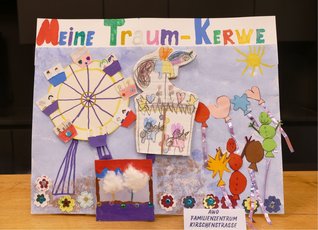 Bunt gestaltetes Kinderplakat des AWO Familienzentrums Kirschenstraße zur „Vernemer Kerwe“. Oben steht in großen, bunten Buchstaben „Meine Traum-Kerwe“. Auf hellviolettem Hintergrund sind verschiedene Kerweattraktionen aus Papier, Stoff und weiteren Bastelmaterialien dargestellt. Links befindet sich ein Riesenrad mit bunt bemalten Gondeln, in der Mitte ein großes Karussell mit selbst gezeichneten Tieren und Figuren. Darunter steht ein kleiner Zuckerwattestand mit zwei weißen Wattebäuschen. Rechts sind bunte Luftballons, Figuren und eine gelbe Sonne zu sehen. Glitzernde Bänder und aufgeklebte Blumen verzieren das Plakat. Unten steht ein Schild mit der Aufschrift „AWO FAMILIENZENTRUM KIRSCHENSTRASSE“.