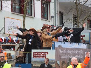 Damen in Westernkleidung rufen von Wagen und winken