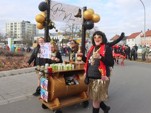 Frauen laufen neben Wagen und verteilen Getränke