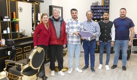 Nihat Akyol (3.v.l.), umgeben von seinen engsten Freunden, präsentiert stolz Wirtschaftsförderer Alexander Schwarz (3.v.r.) seinen eigenen Salon.