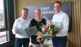 Bürgermeister Matthias Baaß (li.) und Erster Stadtrat Jörg Scheidel würdigen Jenny Dieter für ihr langjähriges ehrenamtliches Engagement.