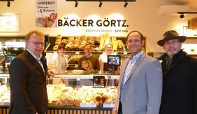 Bürgermeister Matthias Baaß (links), Wirtschaftsförderer Alexander Schwarz (2. v.r.) und Claus Bunte (rechts) gratulieren Peter Görtz mit seinen Mitarbeiterinnern zur Eröffnung der bereits vierten Bäckereifiliale in Viernheim.