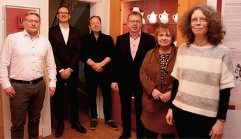 Migration als Teil der Stadtgeschichte: Die Projektbeteiligten (v. r.) Elke Leinenweber, Dr. Brigitta Eckert, Bürgermeister Matthias Baaß, Dr. Gerd Baltes, Alexander Kehry und stellvertretender Amtsleiter Sascha Niebler im Museum in der Abteilung Städtepartnerschaften – einem Bereich, der durch die ehemalige Patenschaft mit Altrohlau (heutiges Tschechien) auch an frühere Migrationsbewegungen erinnert.