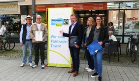 Bei der Übergabe der Urkunde zur Titelerneuerung als „Fairtrade-Stadt“ vor dem Weltladen: (v. l.) Claus Bunte (städtische Wirtschaftsförderung), Robert Toth (Vorstand Eine-Welt-Kreis), Bürgermeister Matthias Baaß, Andrea Ewert und Marion Froschauer (Hauptamt, Steuerungsgruppe Fairtrade).