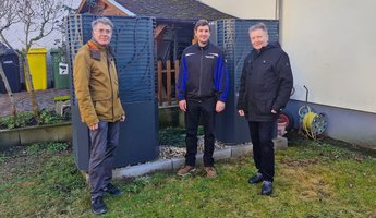 Philipp Granzow (rechts) und Reinhard Wirths (links) vom Brundtlandbüro sowie Mattis Rockrohr, Abteilungsleiter Gas, Wasser, Wärme bei den Stadtwerken, vor der neuen Wärmepumpe in der SBS 55+. In enger Abstimmung und Zusammenarbeit geplant und realisiert – die Umstellung verbessert die CO₂-Bilanz und halbiert die Energiekosten.