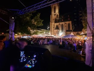 Menschenmenge vor Bühne im Hintergrund die Apostelkirche bei Nacht