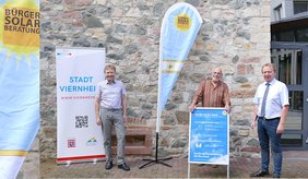 (v. l.) Brundtlandbeauftragter Philipp Granzow, Hans-Peter Dieter (BürgerSolarBeratung Weschnitztal) und Bürgermeister Matthias Baaß. ©Stadt Viernheim Brundtlandbeauftragter Philipp Granzow, Hans-Peter Dieter (BürgerSolarBeratung Weschnitztal) und Bürgermeister Matthias Baaß stehen vor Steinwand mit Plakaten zur BürgerSolarBeratung